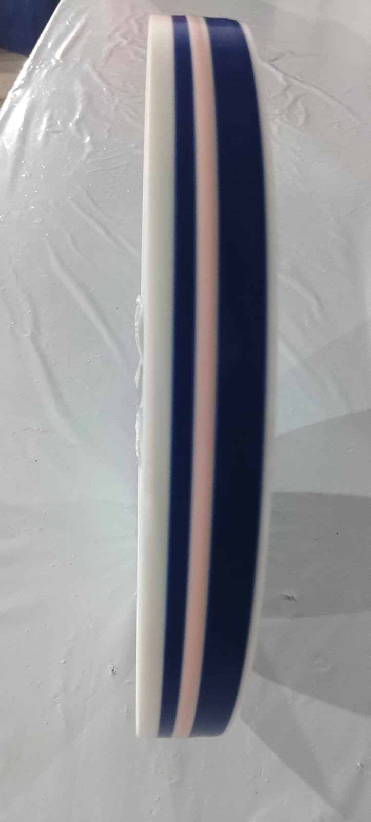Reel of Level 4 tamper-evident film showing navy printed bands either side of the pale heat-indicator stripe