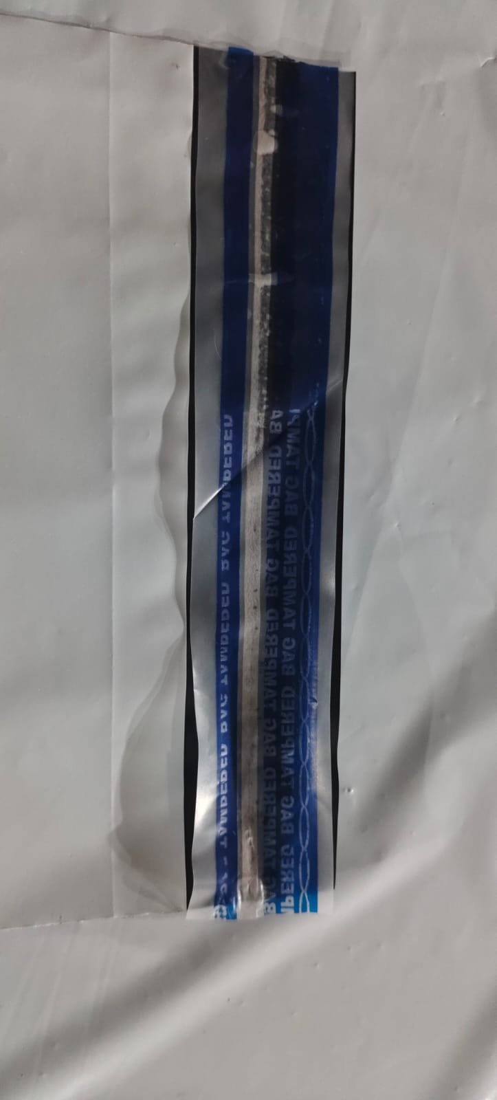 Close view of a bag closure printed with a repeating TAMPERED BAG message in blue