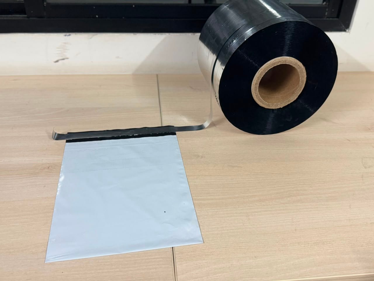 Silicone-coated metallised release film applied along the closure of a white poly mailer